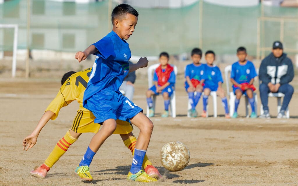 af nepal-kids competing for the soccer ball