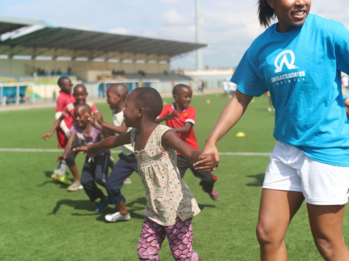 Gira de entrenamiento de fútbol de embajadores: entrenador con niños en el campo
